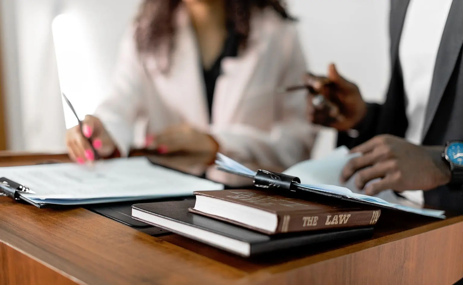 Abogados con manuales legales y un dossier, estudiando el paradigma legal de la IA para las empresas